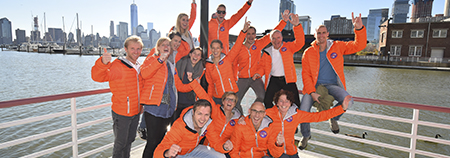 enthousiaste deelnemers groepsfoto in New York in oranje KiKa jassen