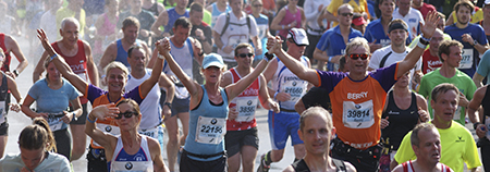 Grote groep runners bij een marathon met een KiKa deelnemer ertussen